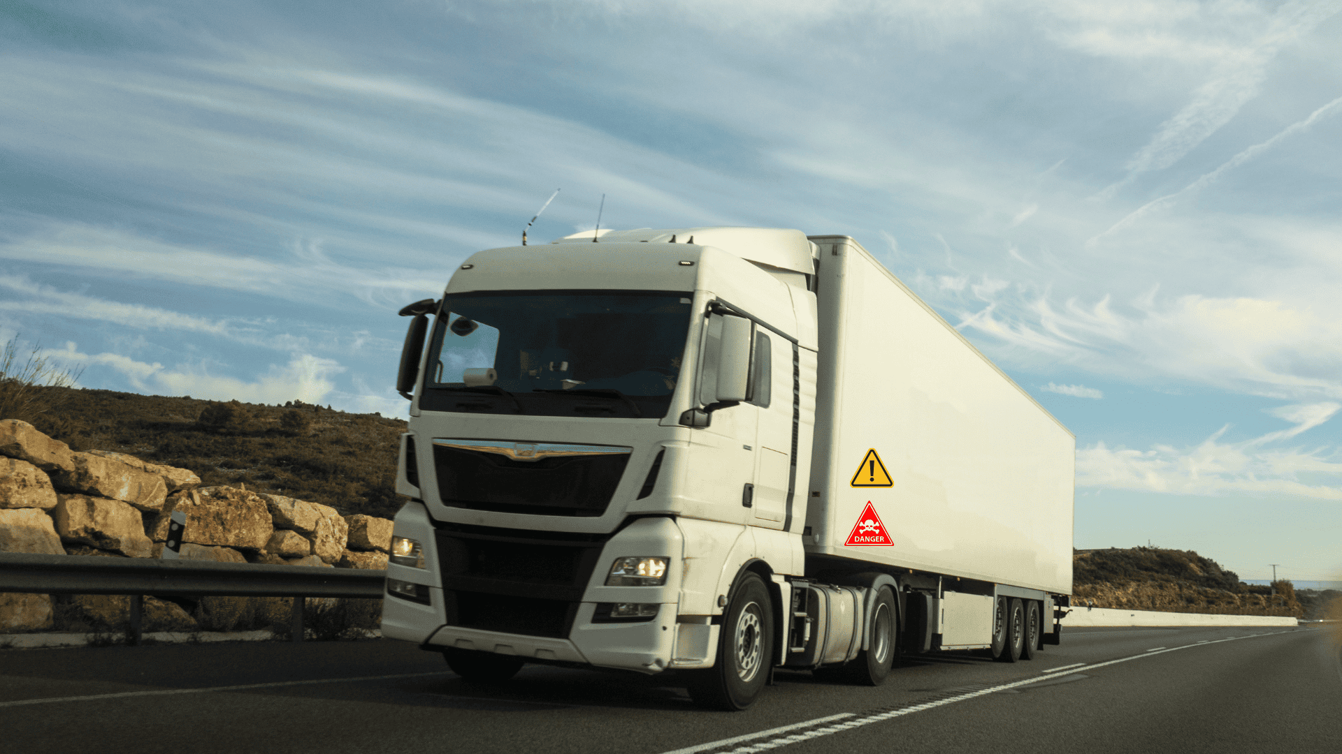 CamionPeligro Imagen de un camión blanco circulando por la carretera con carteles de mercancía peligrosa