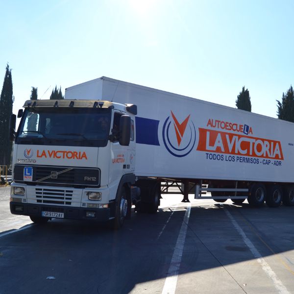 Fotografía de un camión enganchado a un tráiler de carga de autoescuela La Victoria