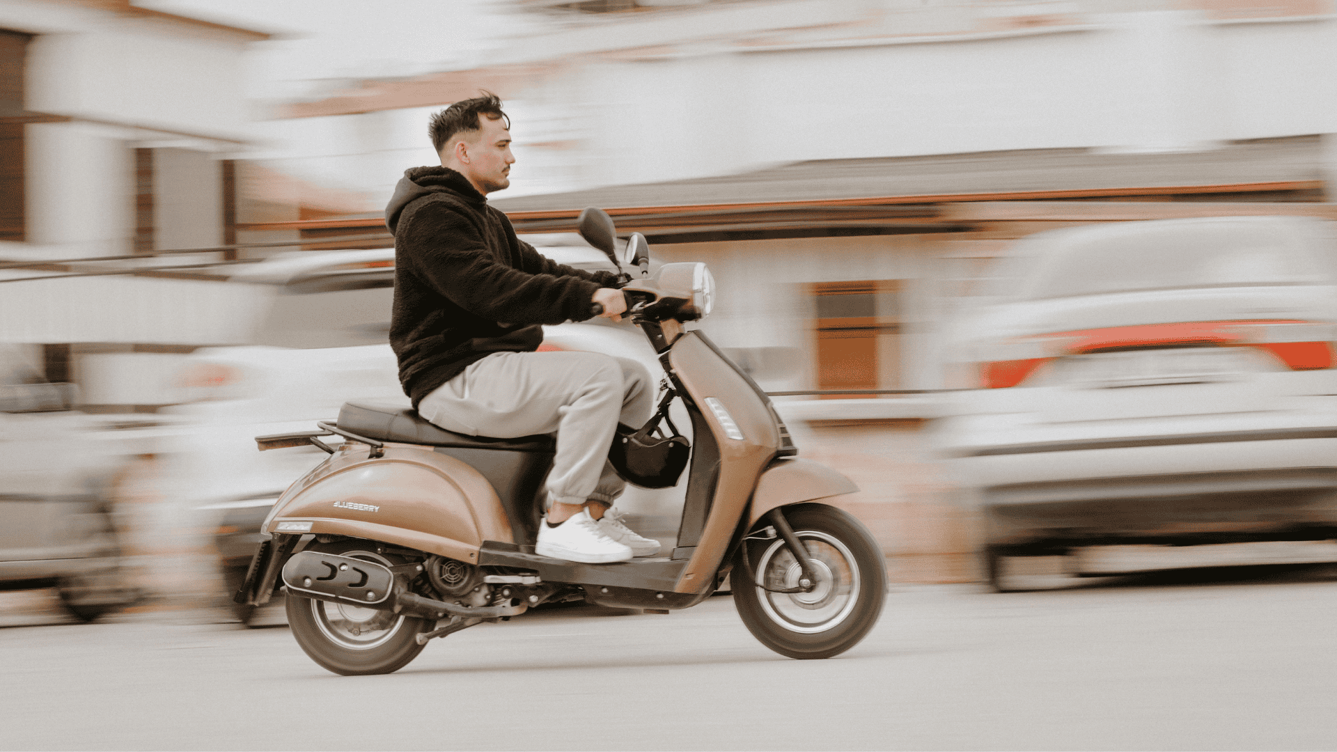 Scooter Imagen de una persona montada en una scooter circulando por la vía pública